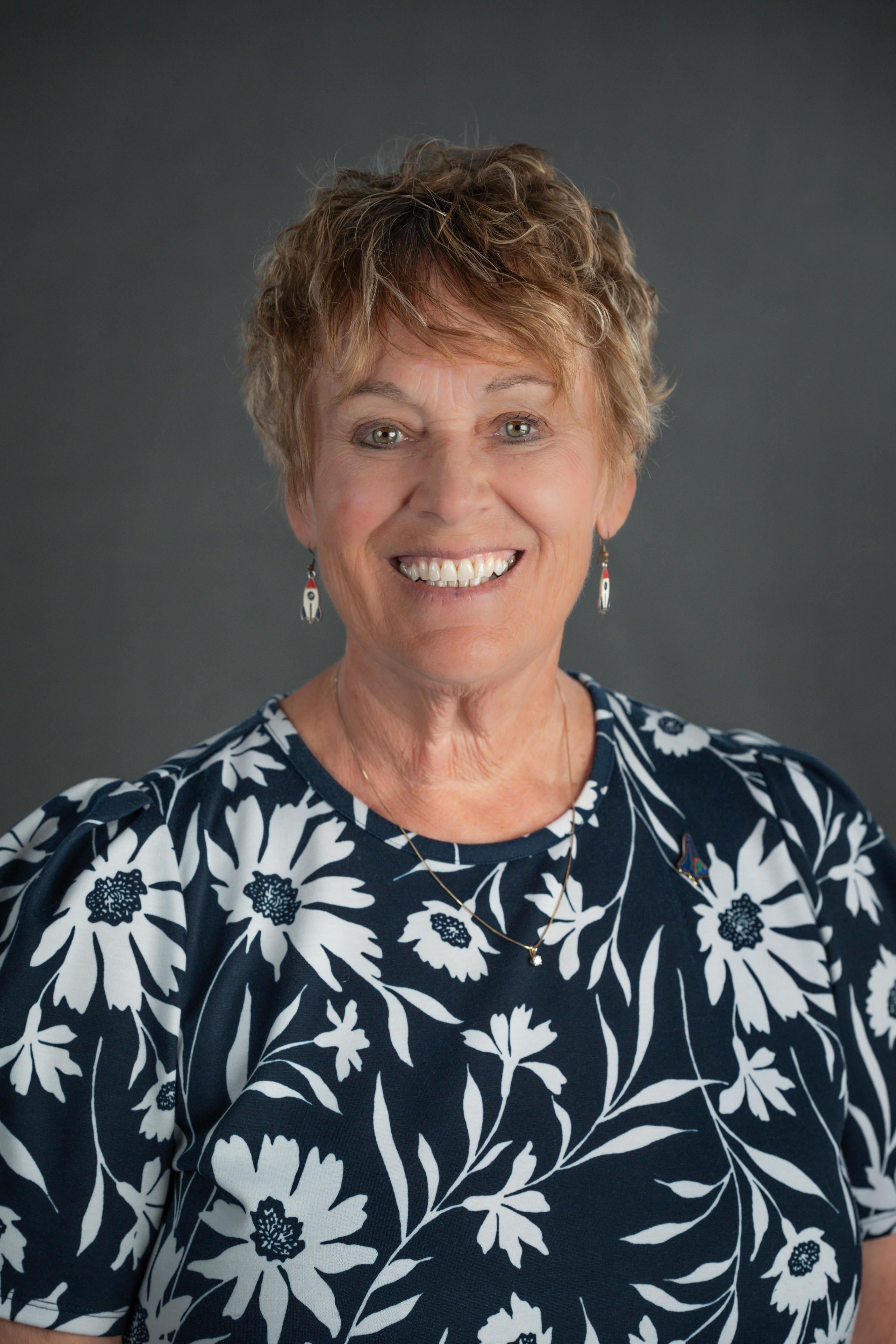 Photo of a female wearing a flowered blouse.